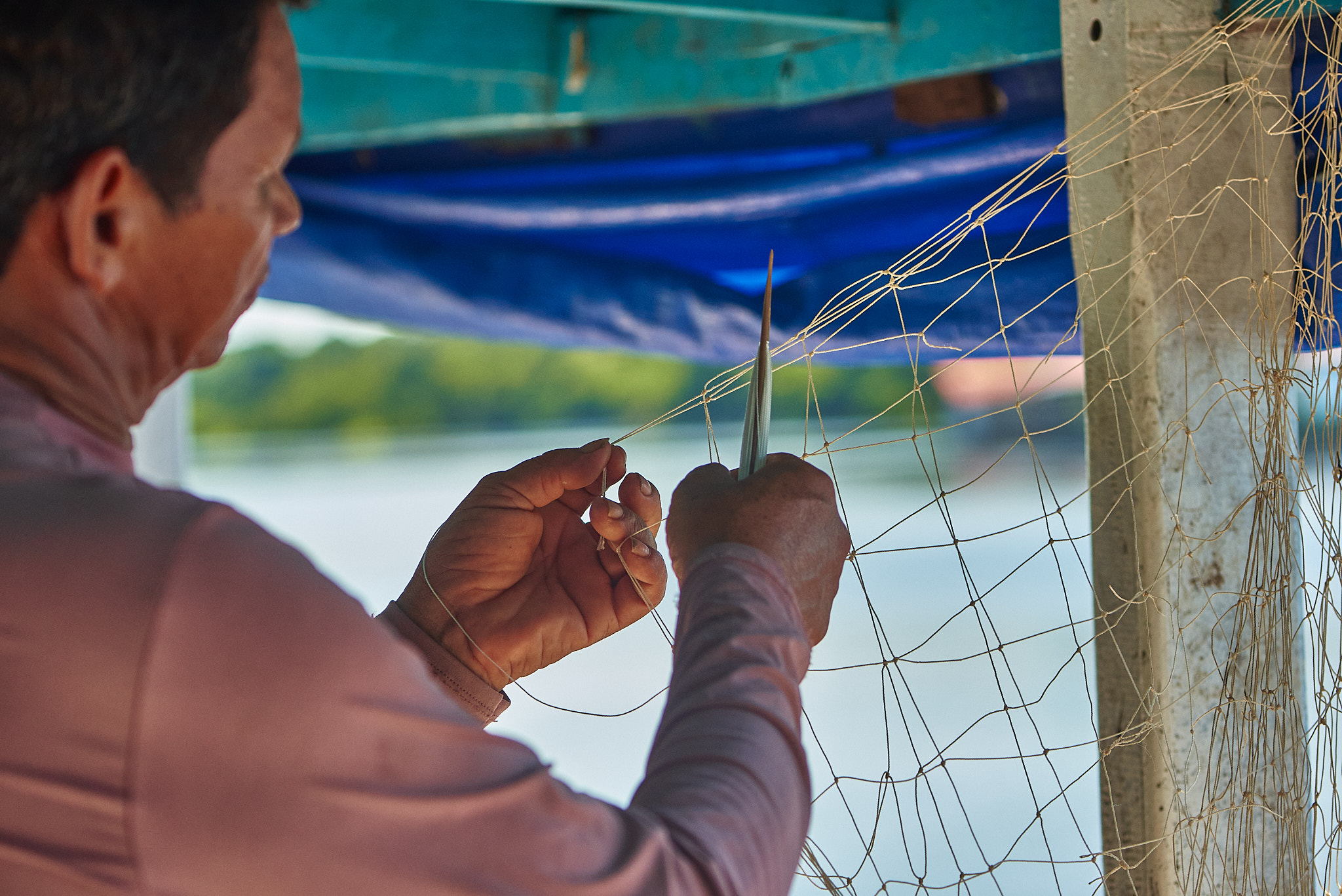 Pescador a tecer uma rede