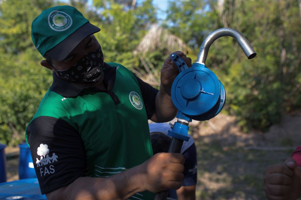 Frentista, Ezio Chagas, mexendo em bomba de gasolina, instalada na Comunidade Saraca, localizada na Reserva de Desenvolvimento Sustentável (RDS) no Amazonas.