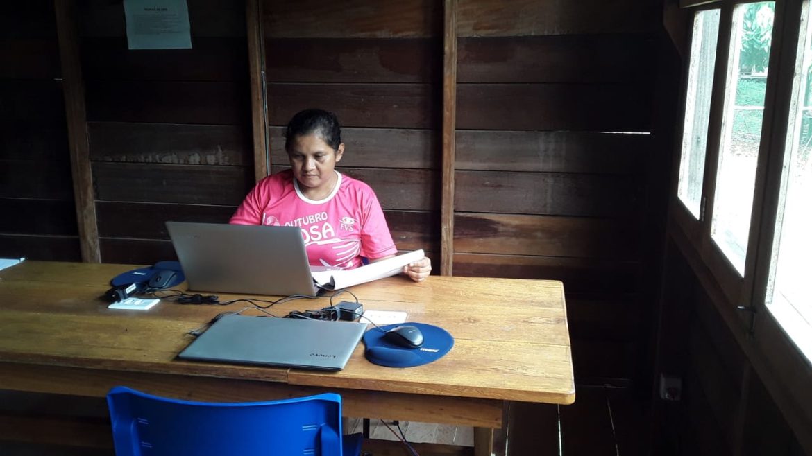 Moradora de comunidade ribeirinha realizando trabalhos pela internet.
