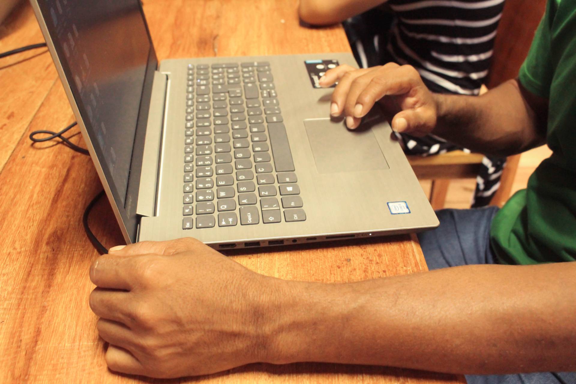 Homem mexendo em notebook durante atividade prática do projeto de conectividade promovido pela Fundação Amazônia Sustentável (FAS).