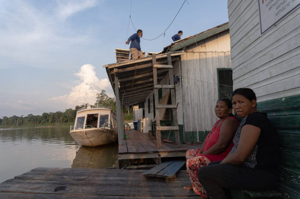 Duas moradoras de comunidades indígenas vendo a implementação de um polo de telessaúde, projeto apoiado pela Fundação Amazônia Sustentável (FAS).