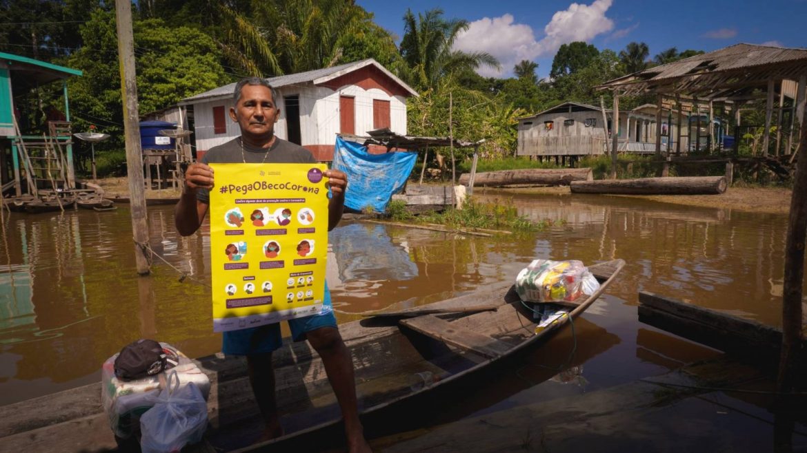 Homem em canoa pegando cesta básica doada pela Fundação Amazônia Sustentável (FAS).