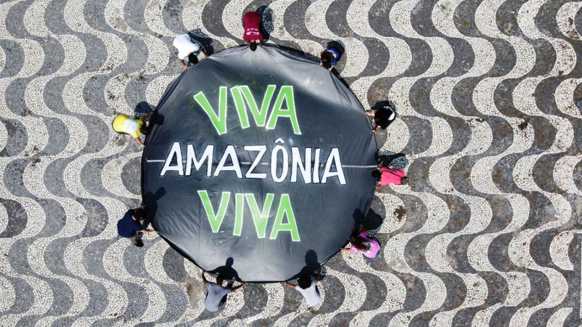 Pessoas no largo de São Sebastião segurando uma faixa escrito "Viva Amazônia Viva", promovendo a Virada Sustentável Manaus, realizada pela Fundação Amazônia Sustentável (FAS).