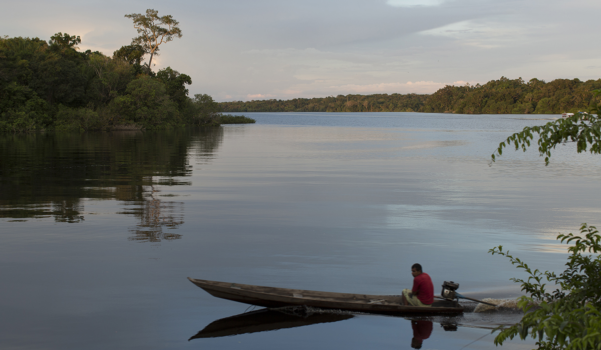 Ribeirinho navegando em sua canoa pelo rio.