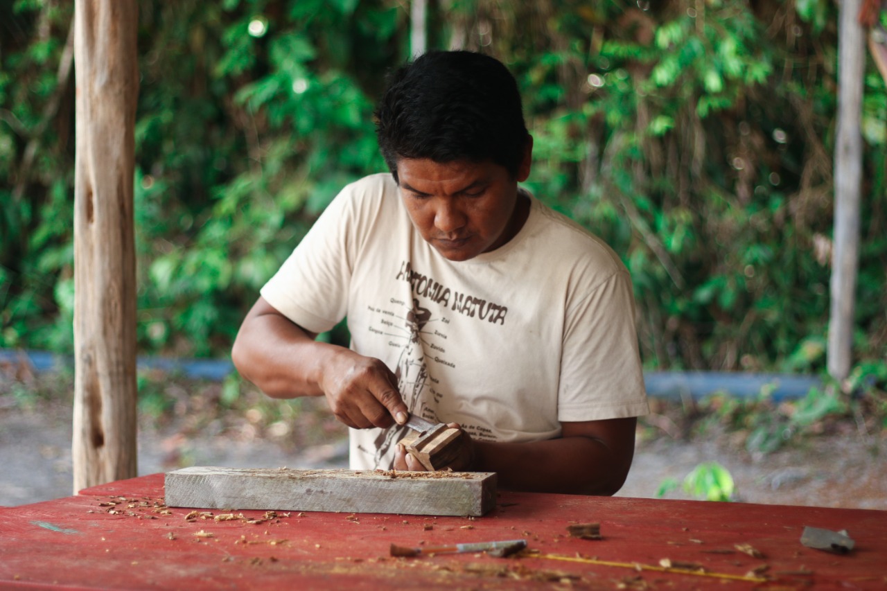 Homem fazendo artesanato em sua oficina.