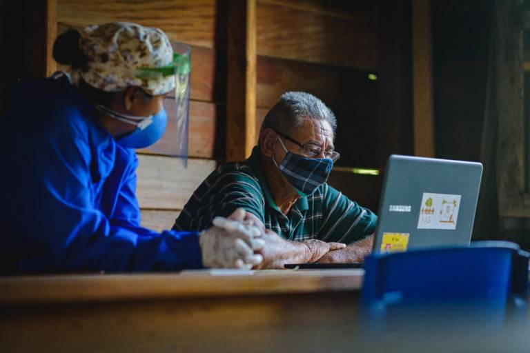 Homem recebendo atendimento de telessaúde em sua comunidade no interior do Amazonas.