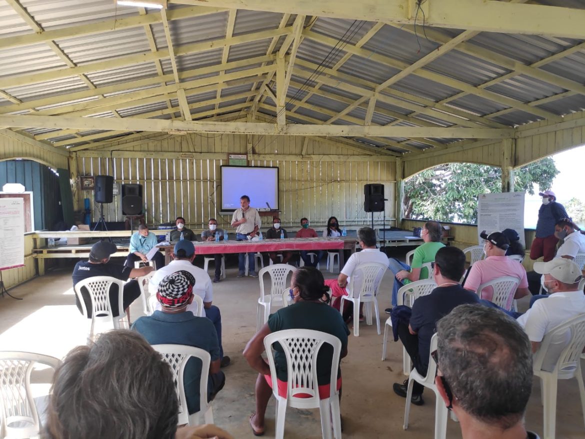 Reunião sobre instalação de sistema de energia solar em residências de comunidades ribeirinhas na Amazônia.