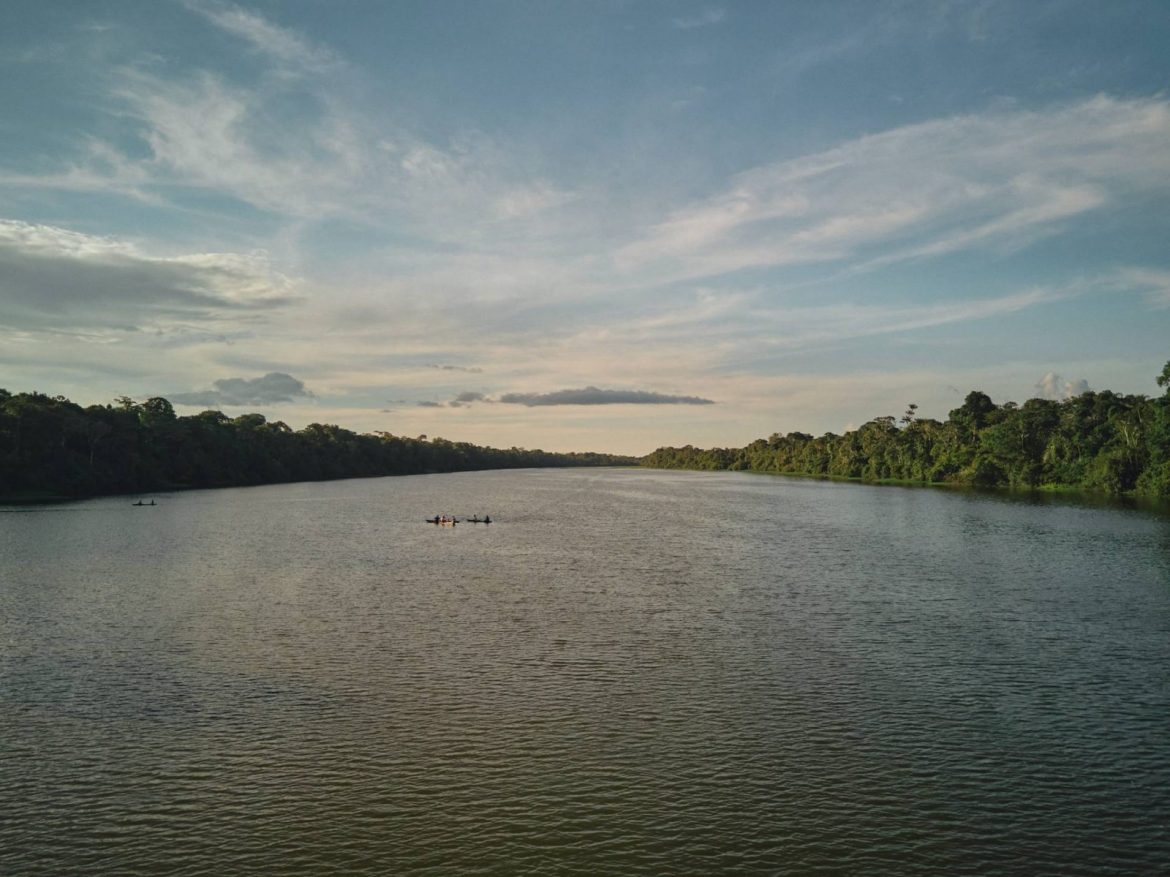 Pessoas atravessando o rio em suas canoas no Amazonas.
