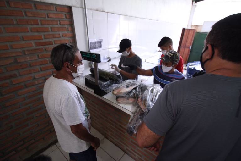 Homens em Feira do Tambaqui, realizada pela Fundação Amazônia Sustentável (FAS).