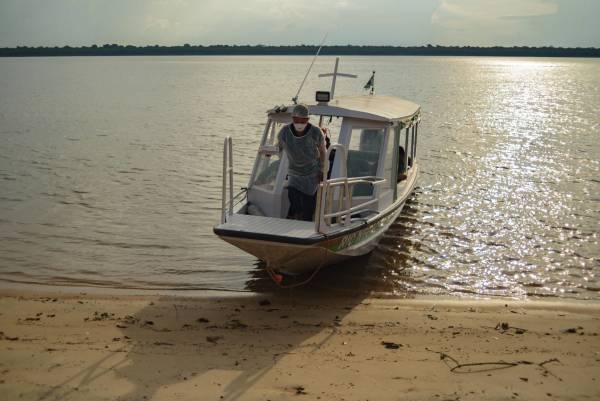 Pessoa saindo de barco às margens do rio Negro.
