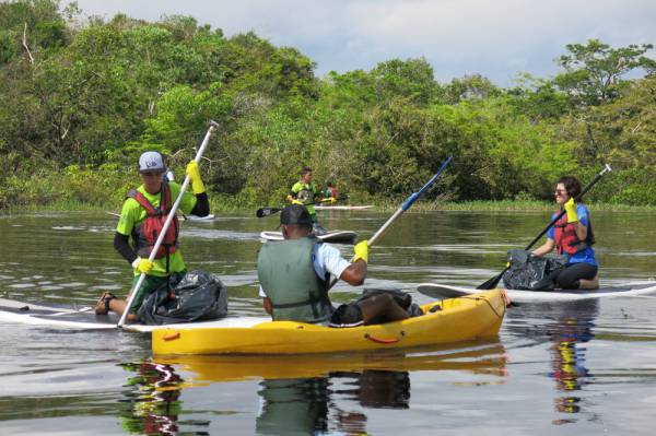 Pessoas praticando canoagem em lago em Manaus.
