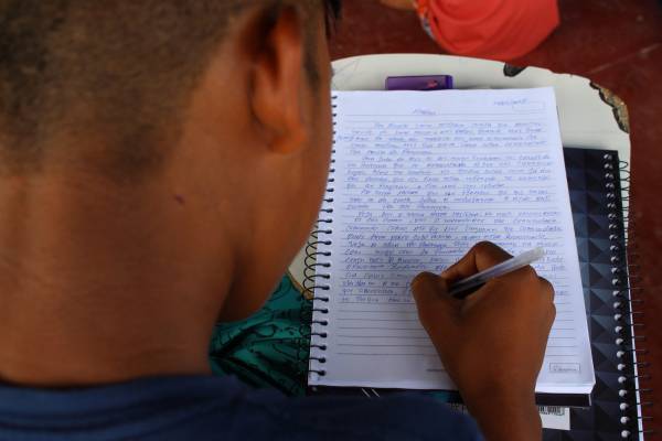 Jovem escrevendo em seu caderno em sala de aula no interior do Amazonas.
