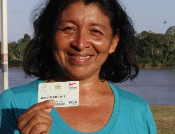 Mulher mostrando carteirinha referente ao programa Bolsa Floresta.