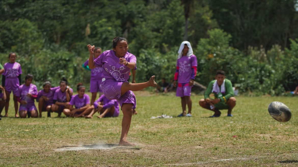 Menina jogando futebol durante Olímpiadas da Floresta, programa realizado pela Fundação Amazônia Sustentável (FAS).