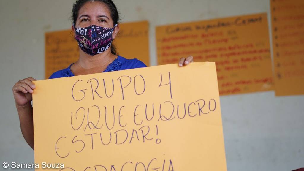 Mulher segurando um cartaz referente a atividade promovida programa de Educação para a Sustentabilidade criado pela Fundação Amazônia Sustentável (FAS).