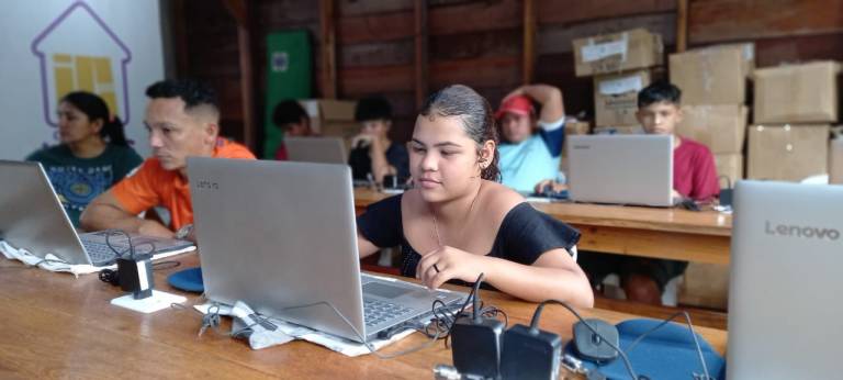 Garota mexendo em notebook, durante curso de informática realizado em comunidade no interior do Amazonas.