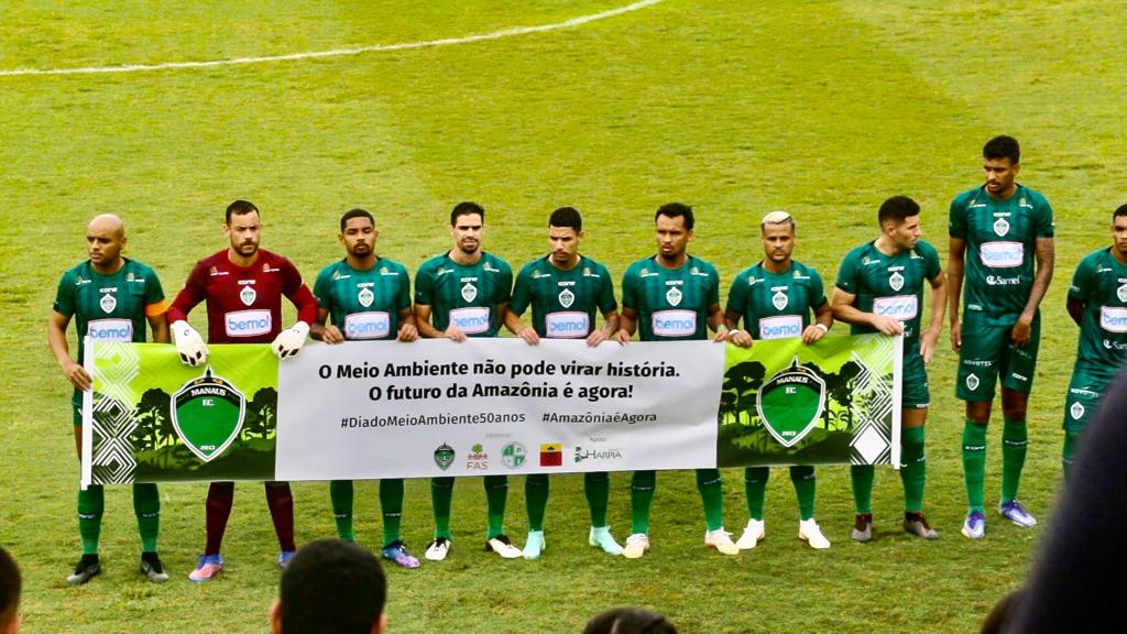 Jogadores do Manaus Futebol Clube, segurando faixa dedicada à data de conscientização pelo meio ambiente.