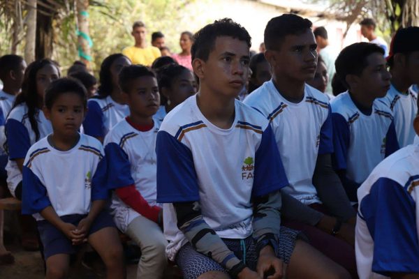 Crianças e jovens sentados participando de atividade realizada pela Fundação Amazônia Sustentável (FAS).