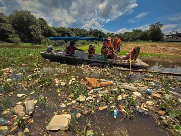 Pessoas dentro de lancha coletando resíduos de igarapé localizado na cidade de Manaus. A ação foi realizada pela Fundação Amazônia Sustentável (FAS) em parceria com a Coca-Cola Brasil