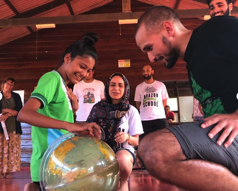 Jovem mostrando um globo para visitantes, em sua comunidade no interior do Amazonas.