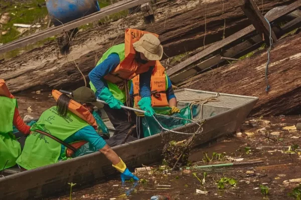 Voluntários da Virada Sustentável Manaus, realizada pela Fundação Amazônia Sustentável (FAS), fazendo coleta de resíduos às margens do rio.