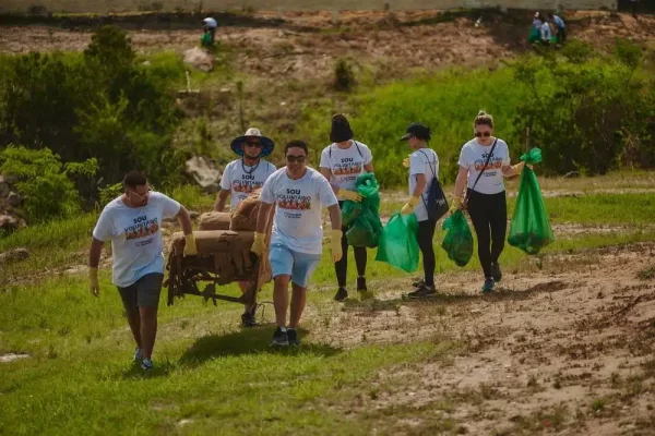 Voluntários carregando sacos de lixos que foram recolhidos das margens do rio em uma das atividades da Virada Sustentável Manaus, realizada pela Fundação Amazônia Sustentável (FAS).