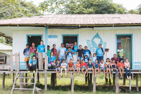 Crianças e adultos reunidos posando para foto do Projeto Escola D'água, que ensina sobre as boas práticas do uso da água.