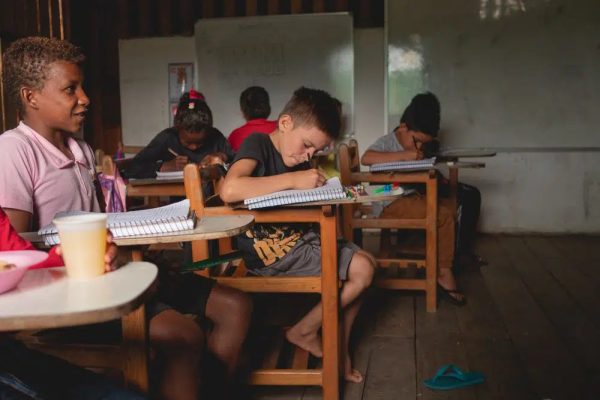Crianças ribeirinhas em sala de aula, aprendendo com o Programa de Educação para a Sustentabilidade realizado pela Fundação Amazônia Sustentável.