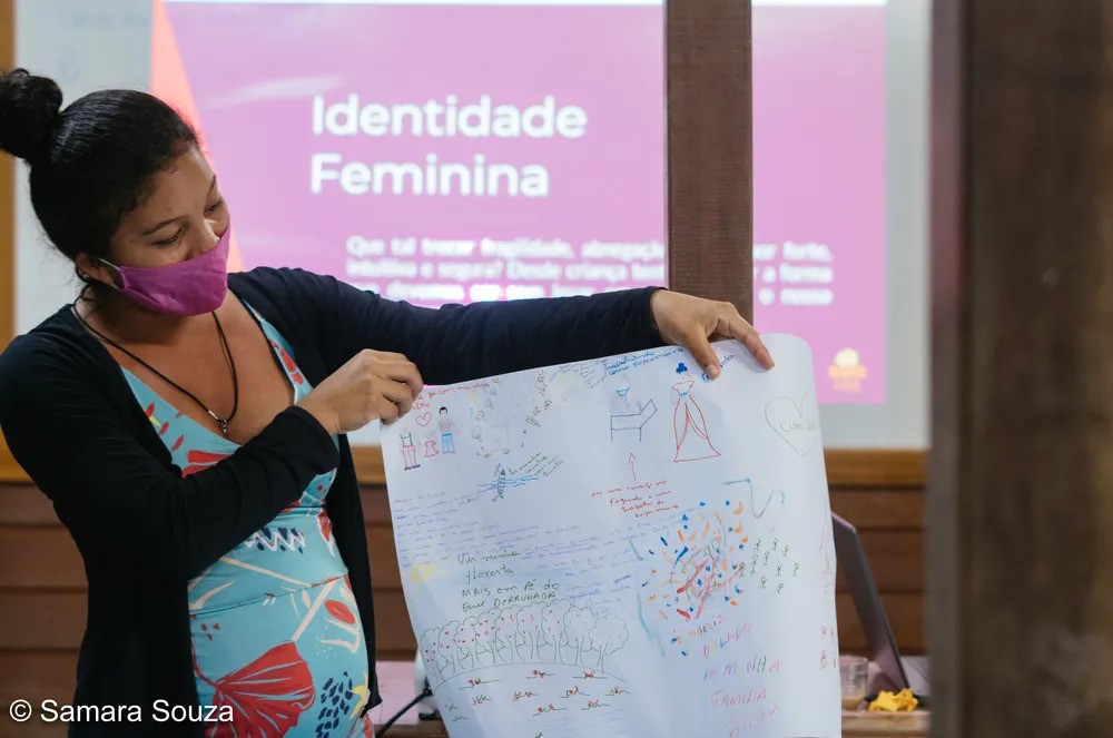 Mulher segurando cartaz que foi feito em uma atividade prática, realizada pela Fundação Amazônia Sustentável.