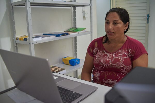 Mulher sentada recebendo atendimento via telessaúde na comunidade Boa Esperança no interior do Amazonas.