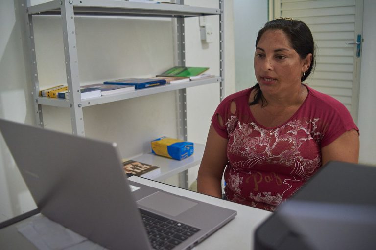 Mulher sentada recebendo atendimento via telessaúde na comunidade Boa Esperança no interior do Amazonas.