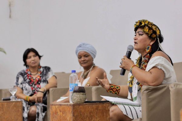 Mulher indígena segurando microfone e palestrando no Seminário Mulheres da Floresta, realizado pela Fundação Amazônia Sustentável (FAS).