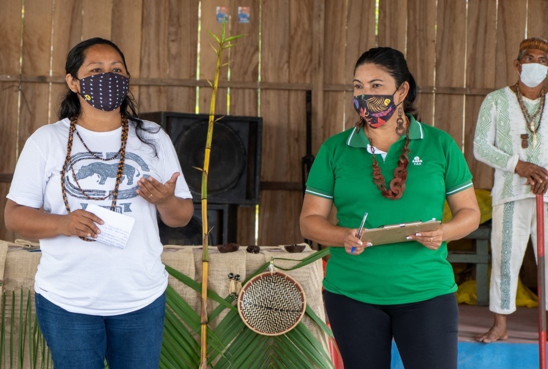 Duas mulheres indígenas conversando com comunidade indígena no interior do Amazonas.