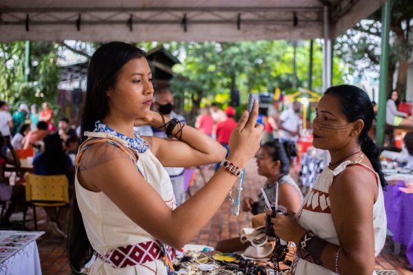 Mulher indígena visitando expositores na Feira da FAS, realizada pela Fundação Amazônia Sustentável (FAS).
