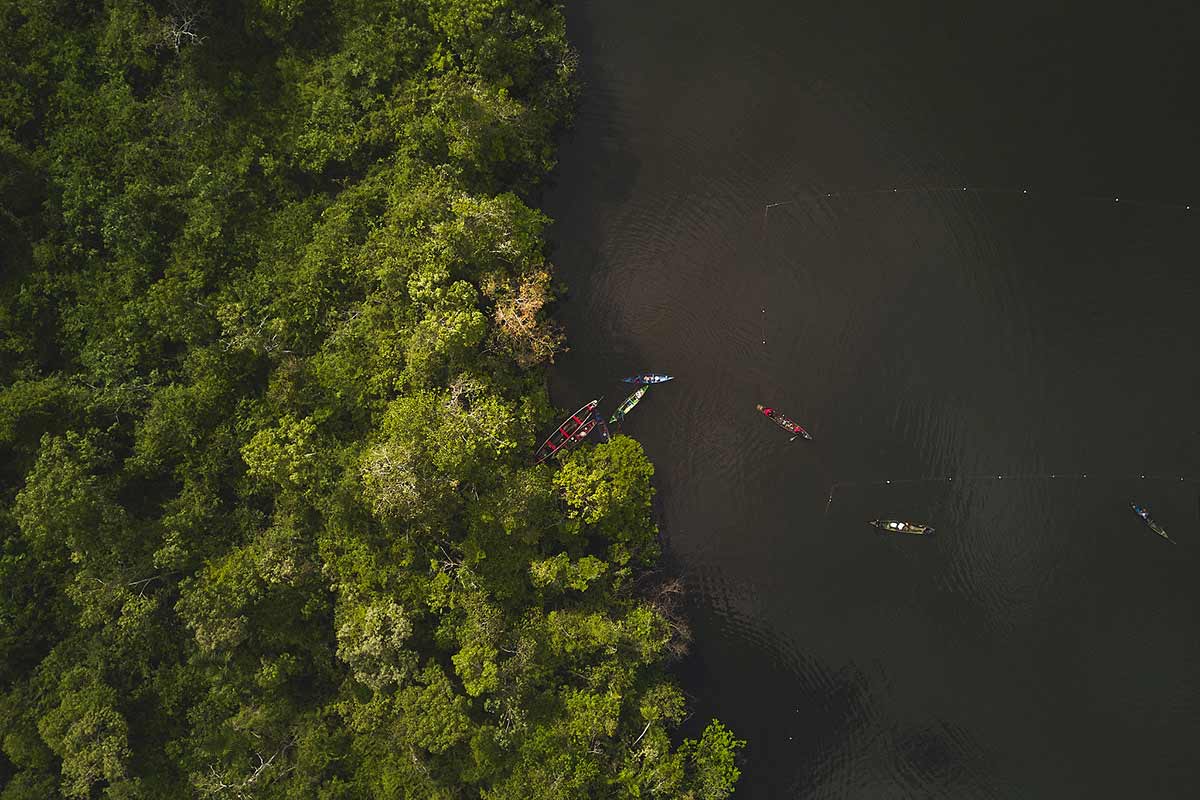 Imagem aérea de pescadores em lago.