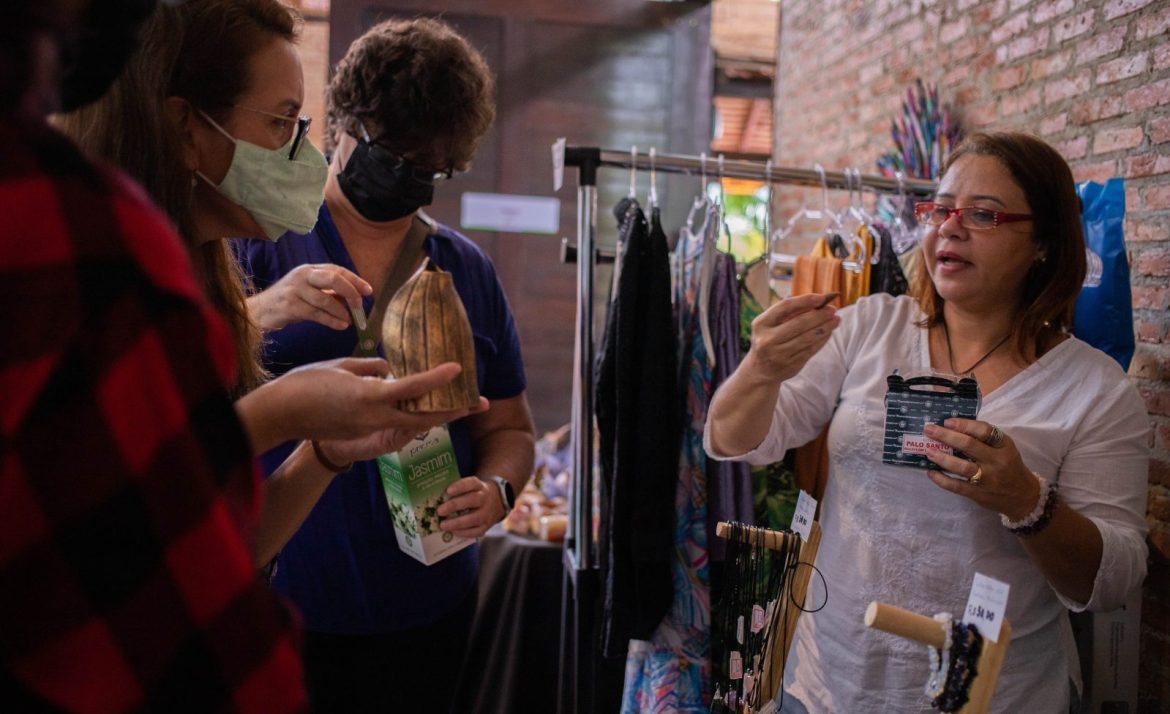 Mulher fazendo venda de suas biojoias durante Feira da FAS, realizada pela Fundação Amazônia Sustentável (FAS).