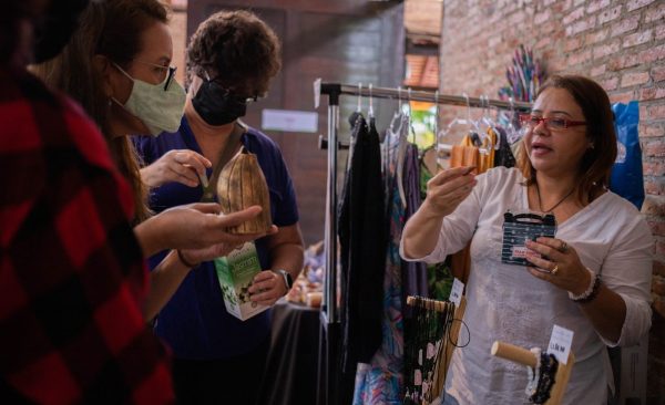 Mulher fazendo venda de suas biojoias durante Feira da FAS, realizada pela Fundação Amazônia Sustentável (FAS).