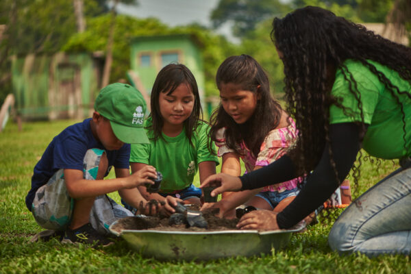 Colaboradora da Fundação Amazônia Sustentável (FAS), durante atividade ambiental com crianças em comunidade no interior do Amazonas.