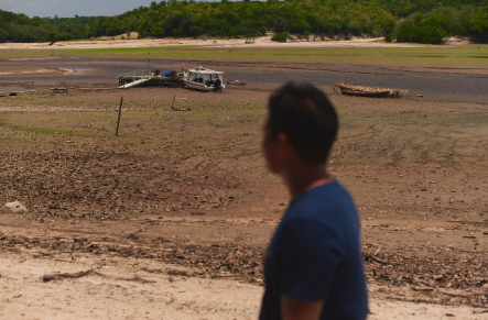 Pessoa observando a margem de um rio durante período de seca na Amazônia