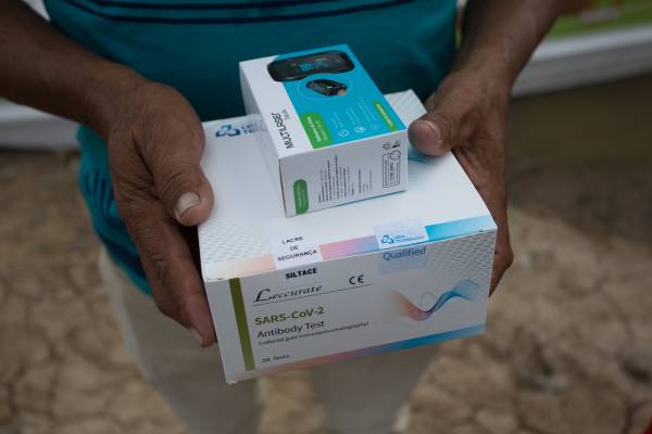 Homem segurando uma caixa de aparelho médico.